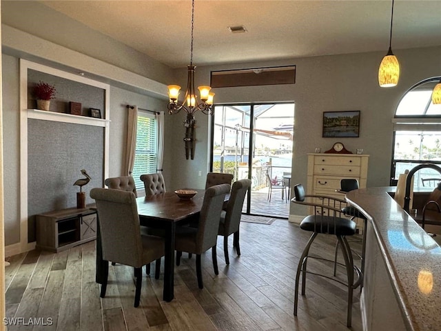 dining room featuring hardwood / wood-style floors and an inviting chandelier