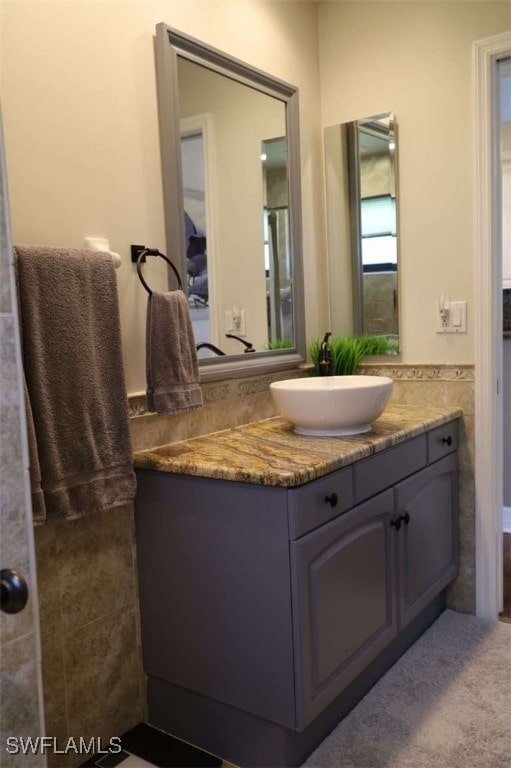 bathroom with vanity and tile walls