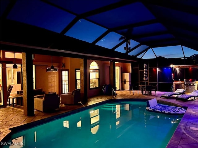 view of pool featuring a lanai, a jacuzzi, outdoor lounge area, ceiling fan, and a patio