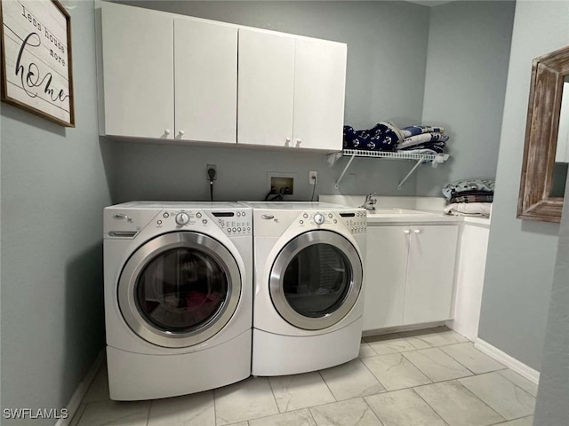 laundry area featuring cabinets, washer and clothes dryer, and sink