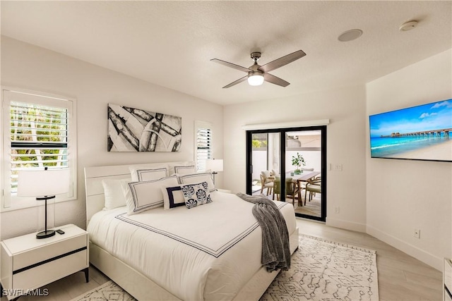 bedroom featuring access to outside, ceiling fan, and light wood-type flooring