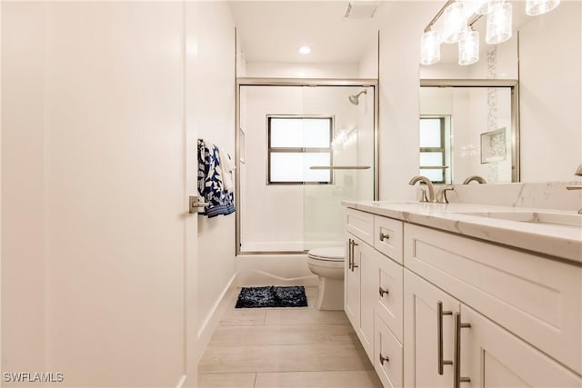 full bathroom with tile patterned floors, vanity, toilet, and enclosed tub / shower combo