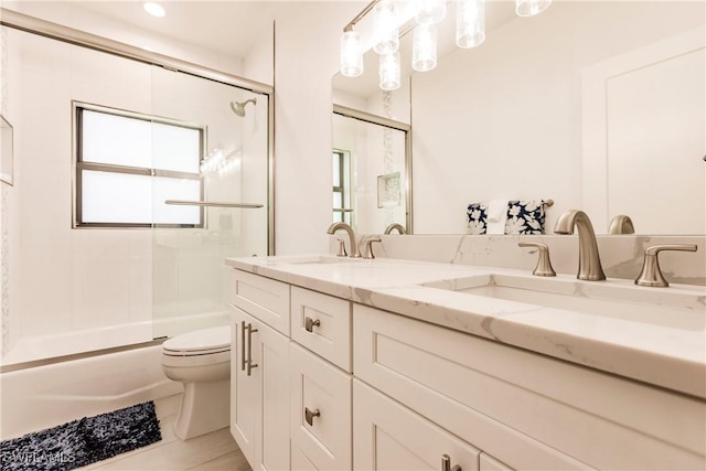 full bathroom featuring tile patterned floors, toilet, vanity, and combined bath / shower with glass door