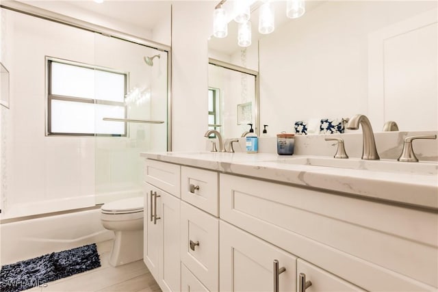 full bathroom with tile patterned floors, vanity, toilet, and bath / shower combo with glass door