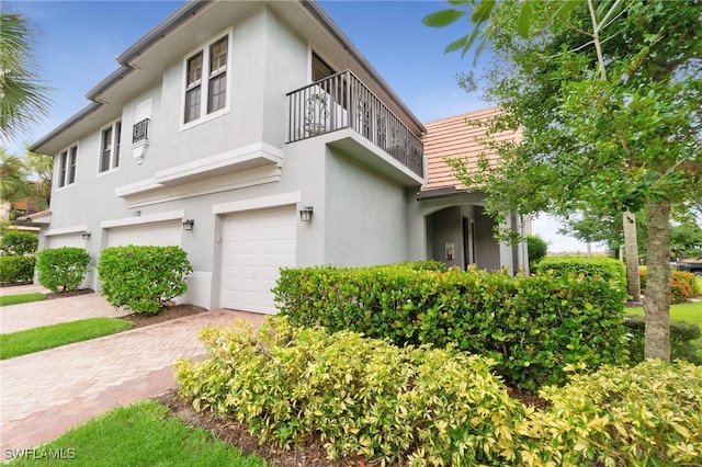 view of front of home featuring a garage and a balcony