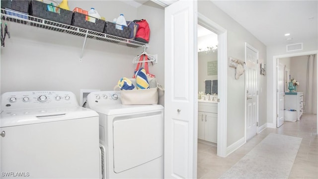 laundry room with laundry area, washing machine and dryer, visible vents, and baseboards