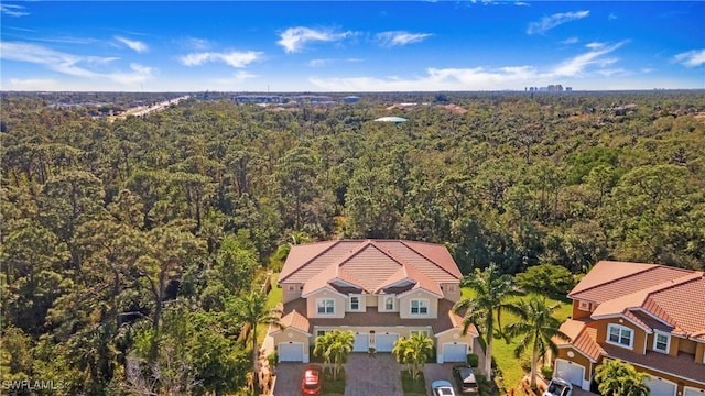 drone / aerial view featuring a wooded view