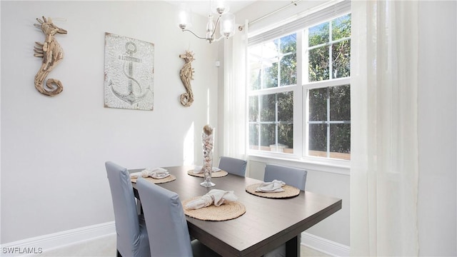 dining room with baseboards and a notable chandelier