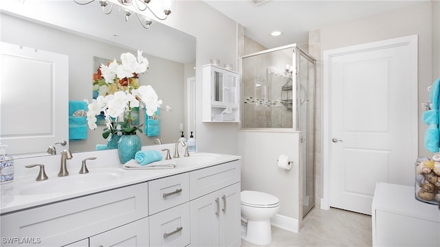 bathroom with tile patterned flooring, vanity, a shower with shower door, and toilet