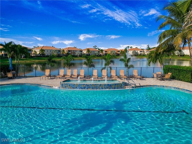 community pool featuring a patio, a water view, fence, and a residential view