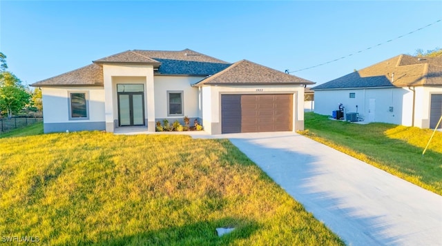 view of front of home featuring a garage, central air condition unit, and a front lawn