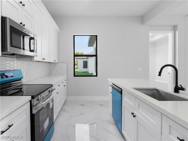 kitchen with white cabinets, decorative backsplash, stainless steel appliances, and sink