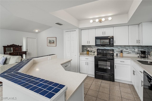 kitchen featuring a center island, black appliances, white cabinets, light tile patterned floors, and tasteful backsplash