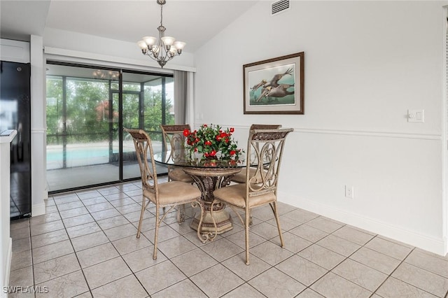 dining area featuring a notable chandelier, lofted ceiling, and light tile patterned floors