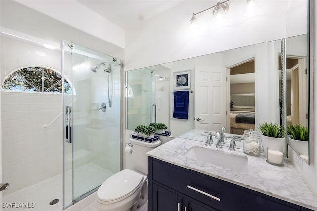 bathroom featuring vanity, an enclosed shower, and toilet