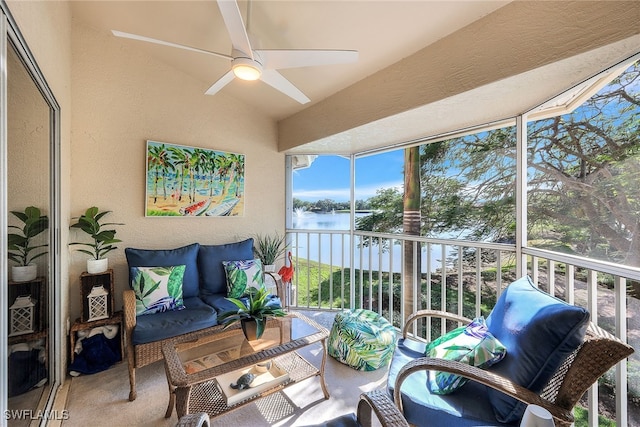 sunroom featuring ceiling fan, a water view, and vaulted ceiling