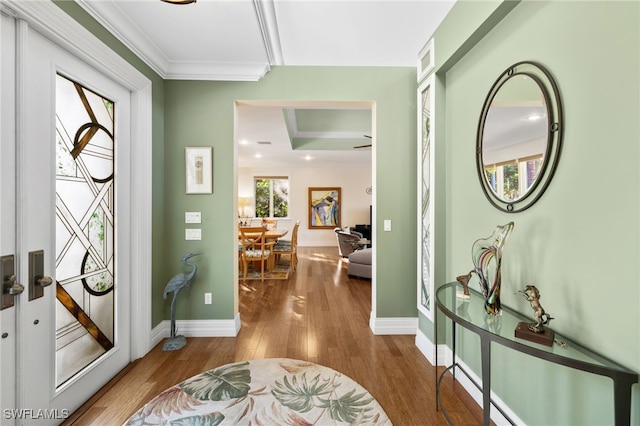 entryway with crown molding, visible vents, baseboards, and wood finished floors