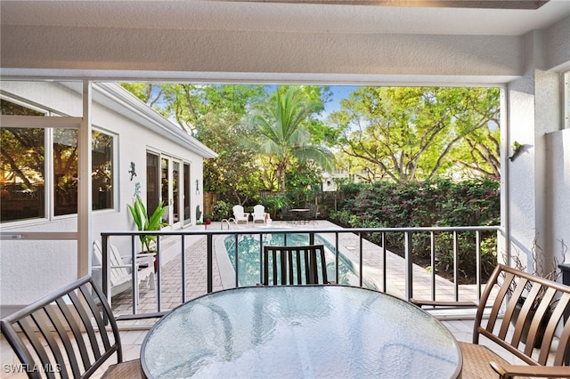 balcony with outdoor dining area and a patio