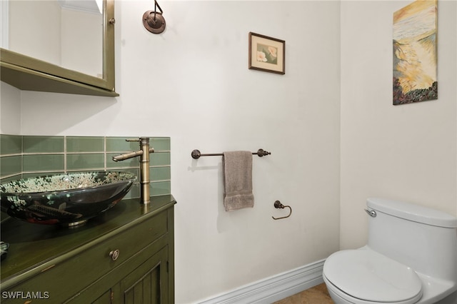 bathroom with vanity, toilet, and backsplash