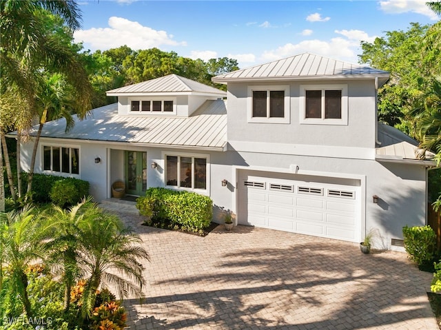 view of front facade featuring a garage, a standing seam roof, and metal roof