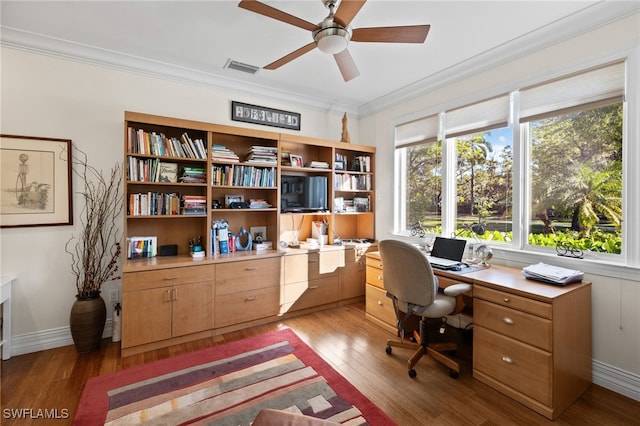 office area with visible vents, baseboards, a ceiling fan, ornamental molding, and light wood-type flooring