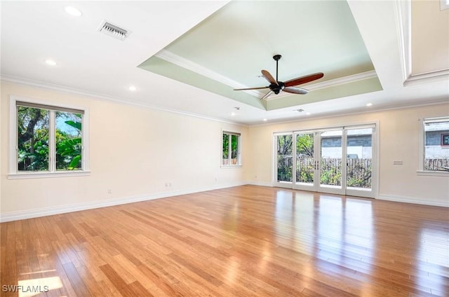 unfurnished room featuring ornamental molding, a wealth of natural light, a ceiling fan, and light wood-style floors