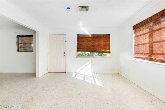 empty room featuring crown molding and a textured ceiling