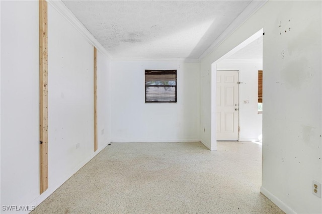 unfurnished room with crown molding and a textured ceiling