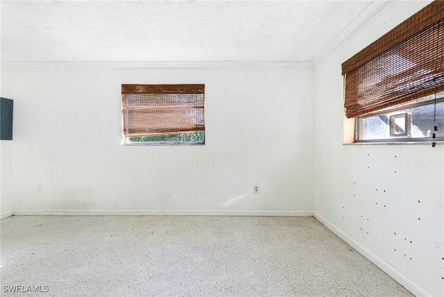 spare room with a textured ceiling and ornamental molding