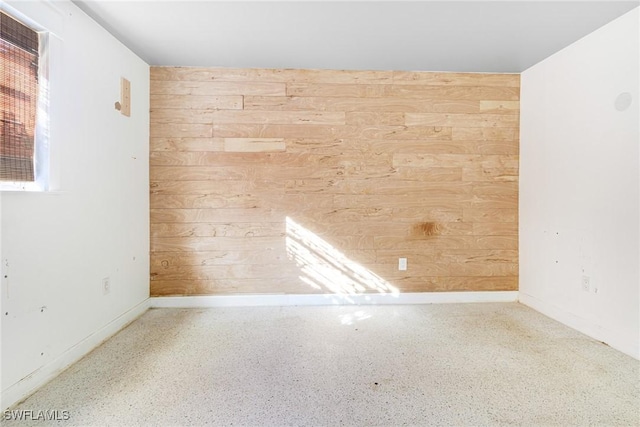 unfurnished room with wood walls