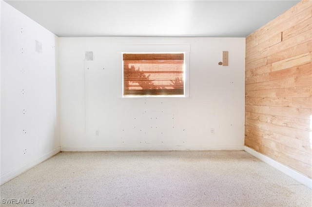 spare room featuring wooden walls