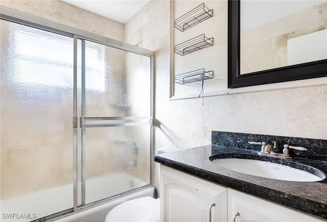 full bathroom with vanity, toilet, and enclosed tub / shower combo