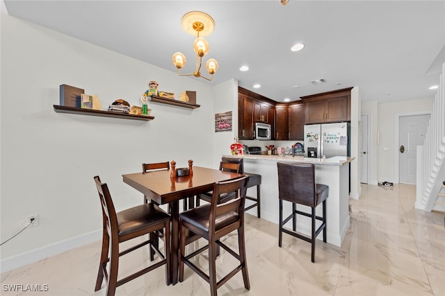 dining space featuring a chandelier and sink