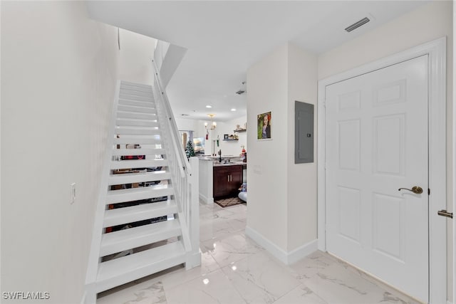 stairway featuring electric panel and sink