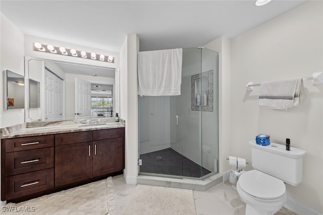 bathroom featuring a shower with door, vanity, and toilet