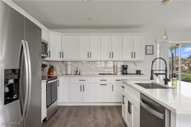 kitchen featuring pendant lighting, sink, hardwood / wood-style flooring, appliances with stainless steel finishes, and white cabinetry