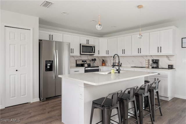 kitchen featuring white cabinetry, sink, hanging light fixtures, an island with sink, and appliances with stainless steel finishes