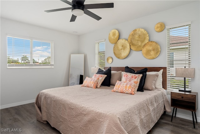 bedroom featuring dark hardwood / wood-style floors, multiple windows, and ceiling fan