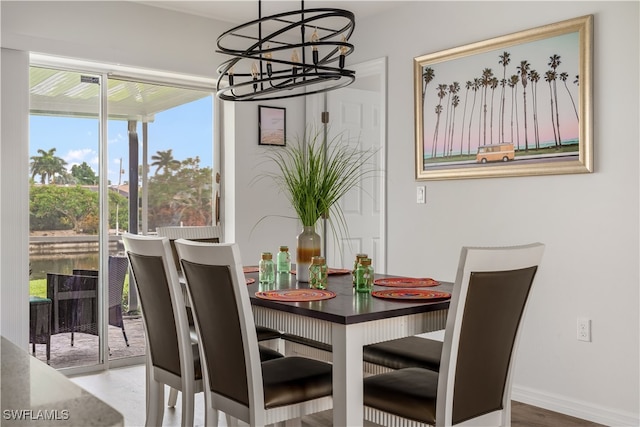 dining space featuring wood-type flooring and a notable chandelier