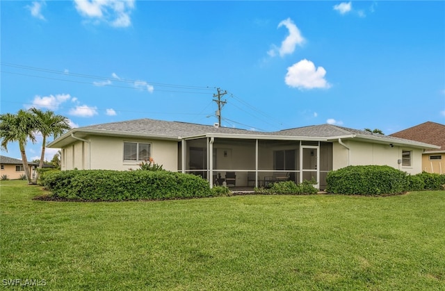 rear view of property with a sunroom and a lawn