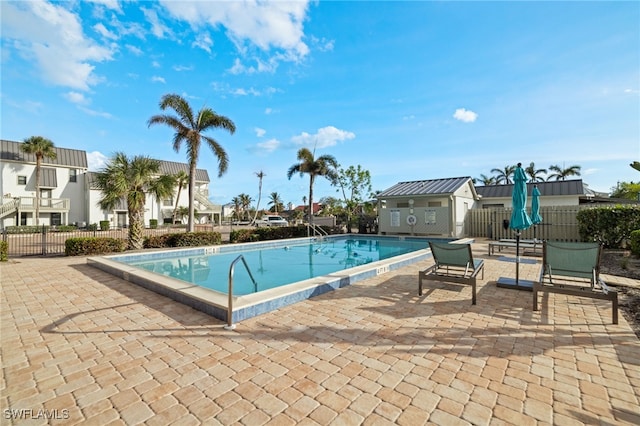 view of swimming pool with a patio area and an outbuilding