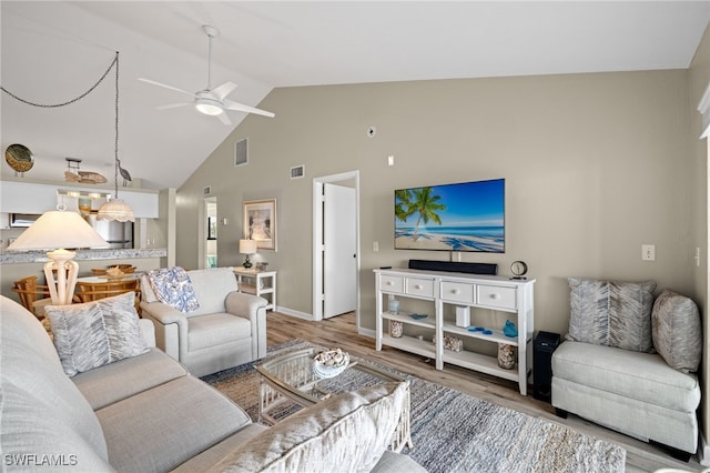 living room with ceiling fan, light hardwood / wood-style flooring, and high vaulted ceiling