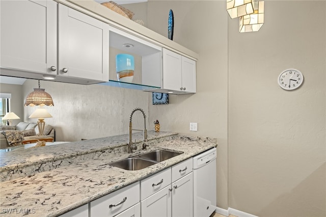 kitchen featuring white cabinetry, dishwasher, sink, and light stone counters