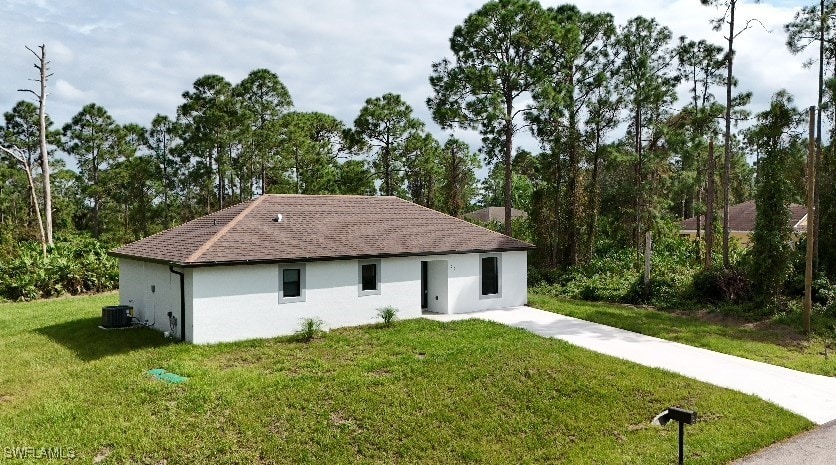 view of front of house featuring a front yard and central AC