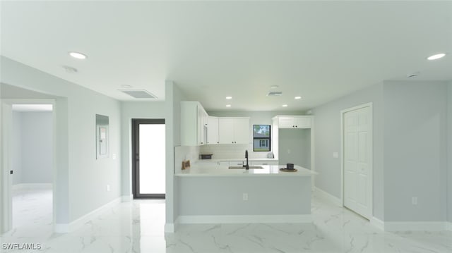 kitchen with tasteful backsplash, white cabinetry, and sink