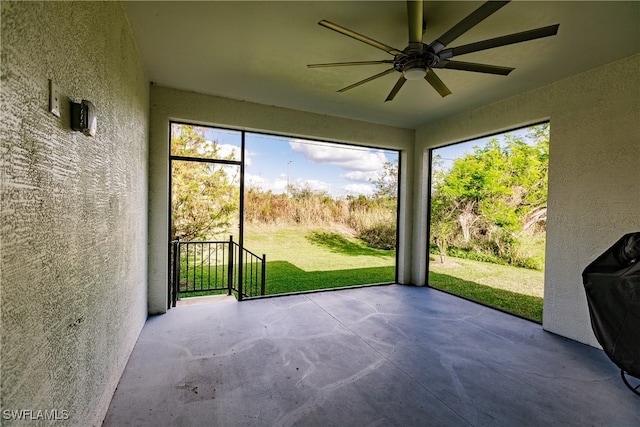 unfurnished sunroom featuring ceiling fan