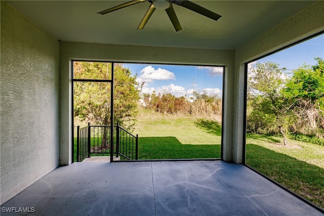 unfurnished sunroom featuring ceiling fan