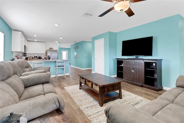 living room with ceiling fan and light hardwood / wood-style floors