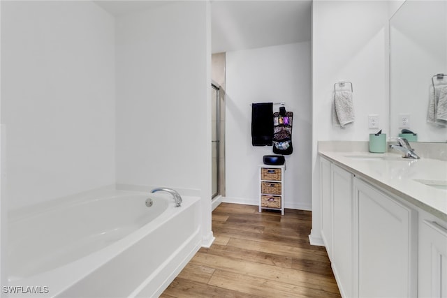 bathroom with hardwood / wood-style flooring, vanity, and independent shower and bath