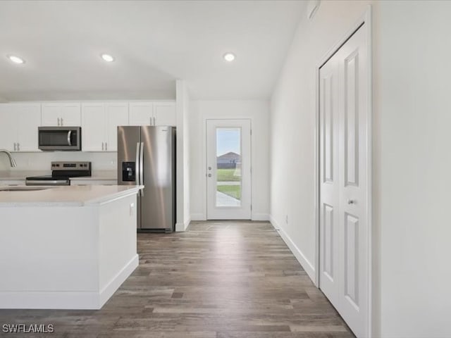 kitchen with white cabinets, appliances with stainless steel finishes, and dark hardwood / wood-style floors